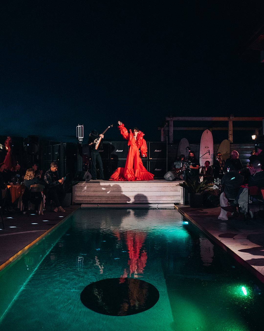 Poolside performance with singer in red dress