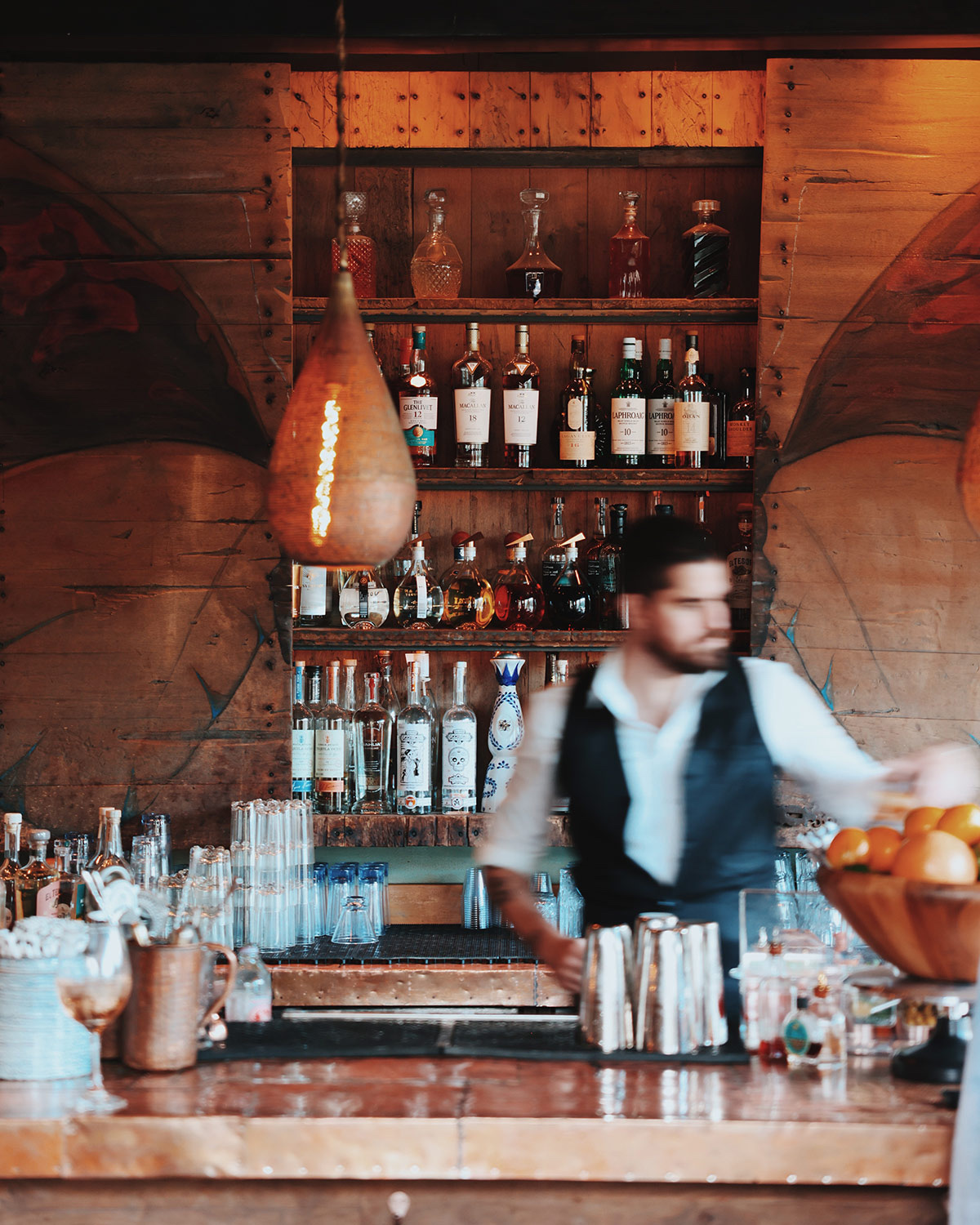 Bartender working behind a warmly lit rustic bar