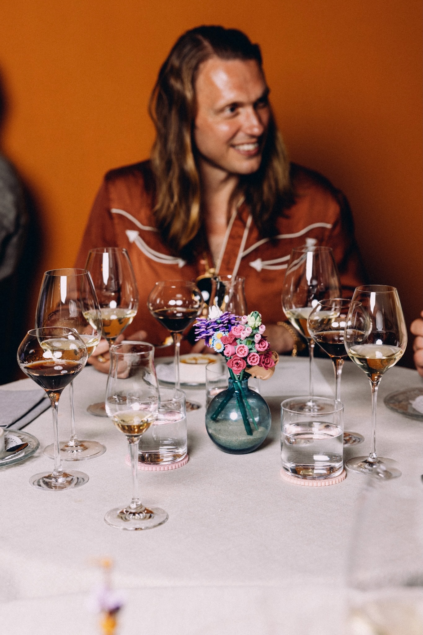 Guest smiling at a dinner table with wine glasses