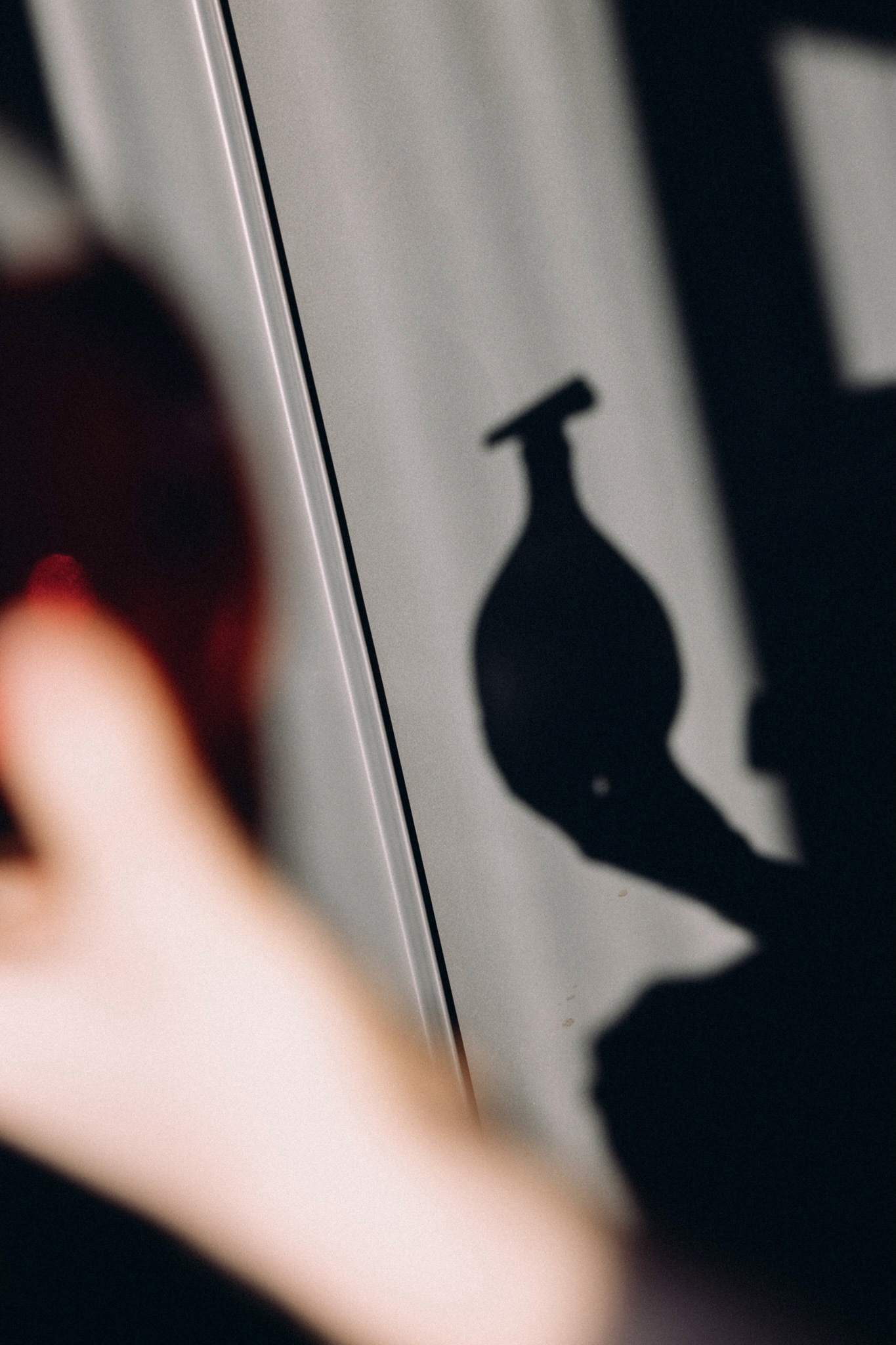 Bottle silhouette shadow cast on curtain